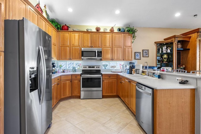 kitchen featuring stainless steel appliances, kitchen peninsula, and sink