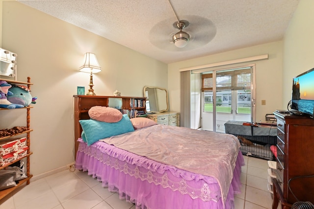 tiled bedroom with ceiling fan and a textured ceiling