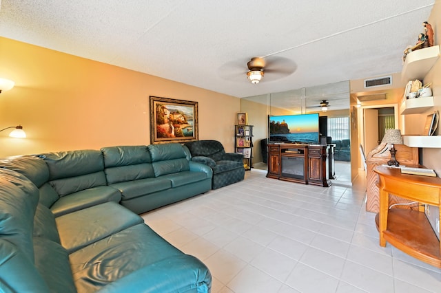 living room featuring light tile patterned flooring, a textured ceiling, and ceiling fan