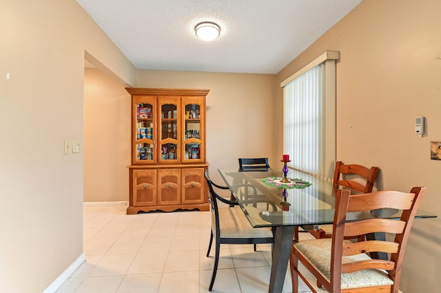 tiled dining space with a textured ceiling