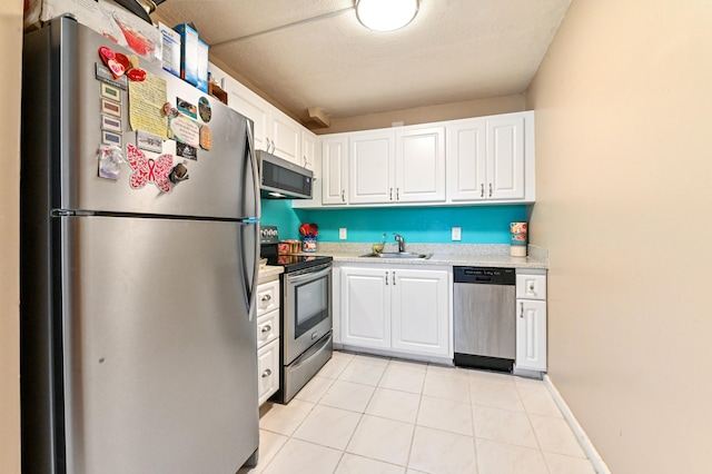 kitchen featuring sink, white cabinetry, stainless steel appliances, and light tile patterned floors