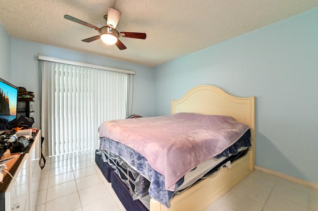 bedroom featuring a textured ceiling, light tile patterned floors, and ceiling fan