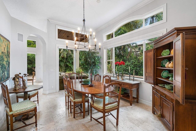 414 NW 13th St, Delray Beach, FL 33444 - dining space with arched walkways, ornamental molding, baseboards, a chandelier, and a towering ceiling