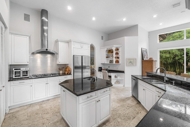 414 NW 13th St, Delray Beach, FL 33444 - kitchen featuring open shelves, wall chimney exhaust hood, a sink, stainless steel appliances, and a kitchen island with sink