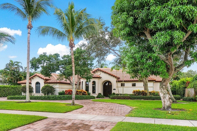 414 NW 13th St, Delray Beach, FL 33444 - mediterranean / spanish house with a tile roof, stucco siding, and a front lawn