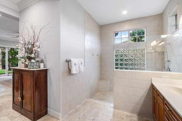 bathroom featuring vanity, tile walls, ornamental molding, and tiled shower