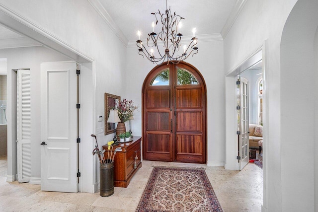 entrance foyer with an inviting chandelier and ornamental molding