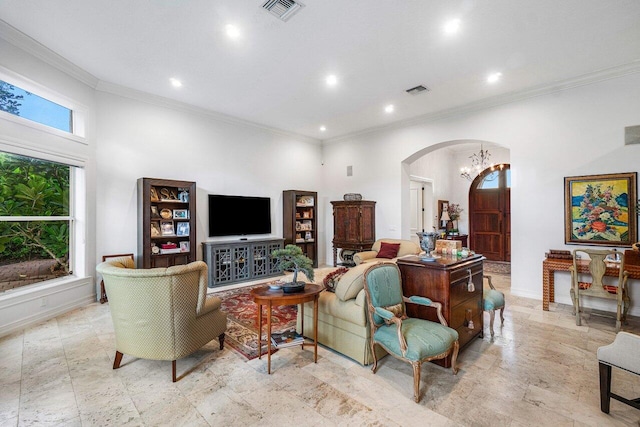 living room featuring a notable chandelier, a towering ceiling, and crown molding