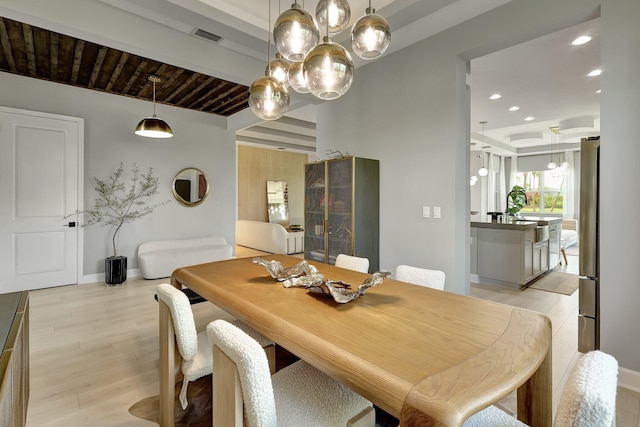 dining area with beam ceiling, light hardwood / wood-style floors, wooden ceiling, and sink