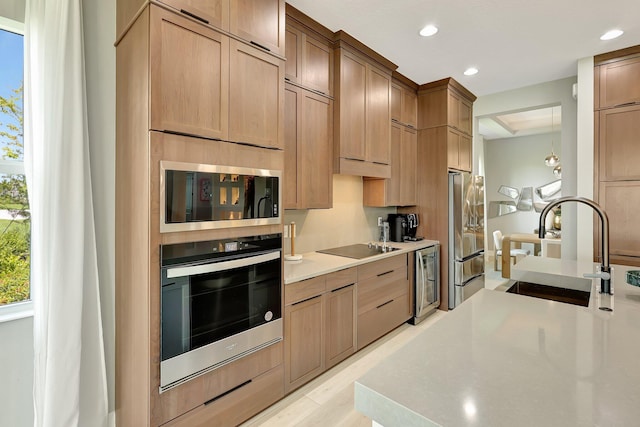 kitchen with appliances with stainless steel finishes, light hardwood / wood-style floors, sink, and wine cooler