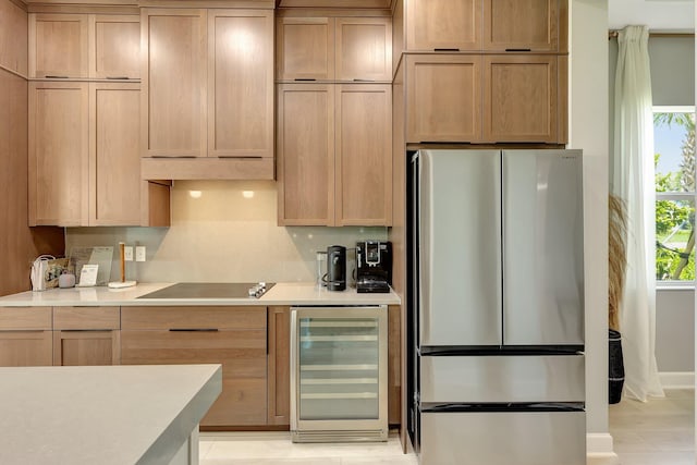 kitchen with stainless steel refrigerator, black electric stovetop, decorative backsplash, and beverage cooler