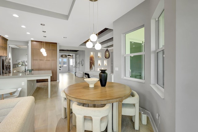 dining room featuring sink and light hardwood / wood-style flooring