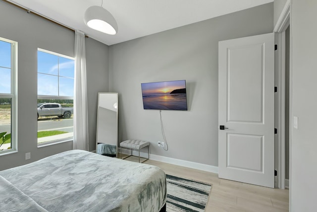 bedroom featuring light hardwood / wood-style flooring and multiple windows