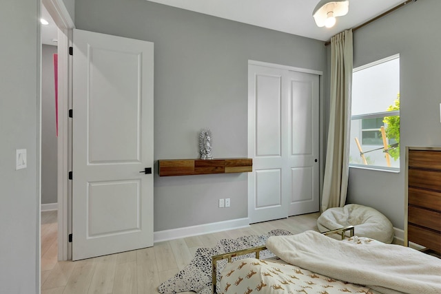 bedroom with a closet and light hardwood / wood-style floors