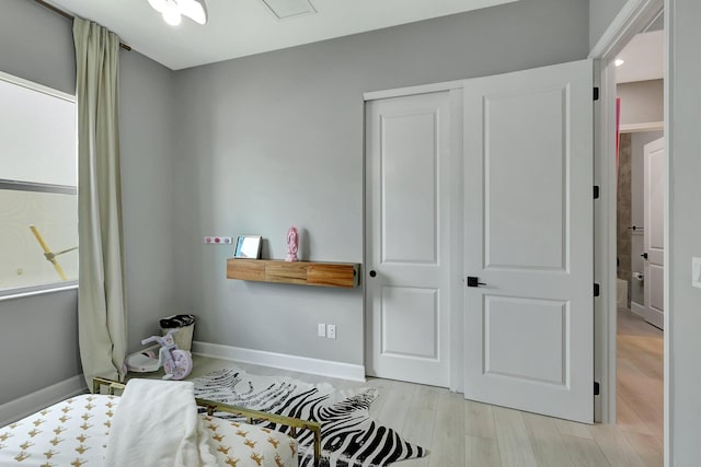 bedroom with light hardwood / wood-style floors and a closet