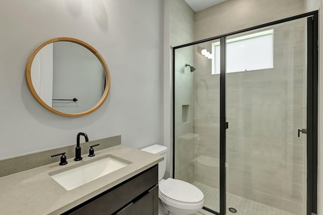 bathroom with walk in shower, vanity, and toilet