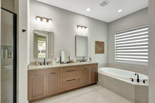 bathroom with tile patterned flooring, independent shower and bath, and vanity