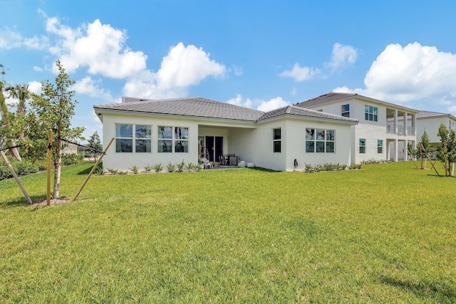 rear view of house featuring a yard