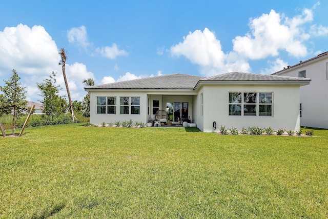 rear view of property with a yard and a patio area