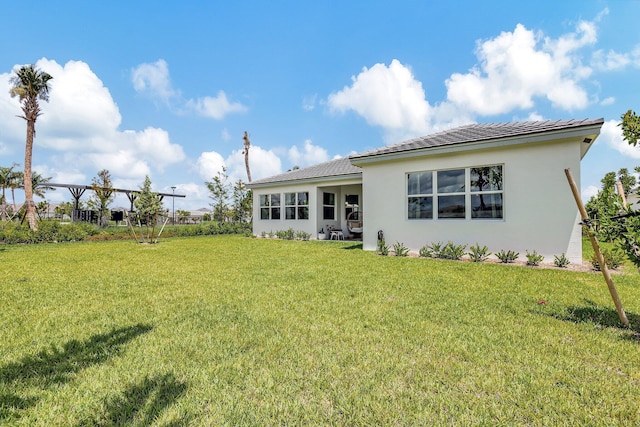 rear view of house featuring a yard