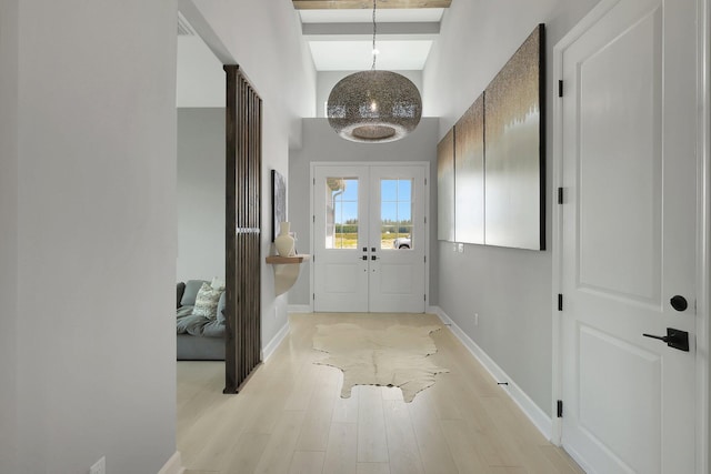 entrance foyer with french doors and light hardwood / wood-style flooring