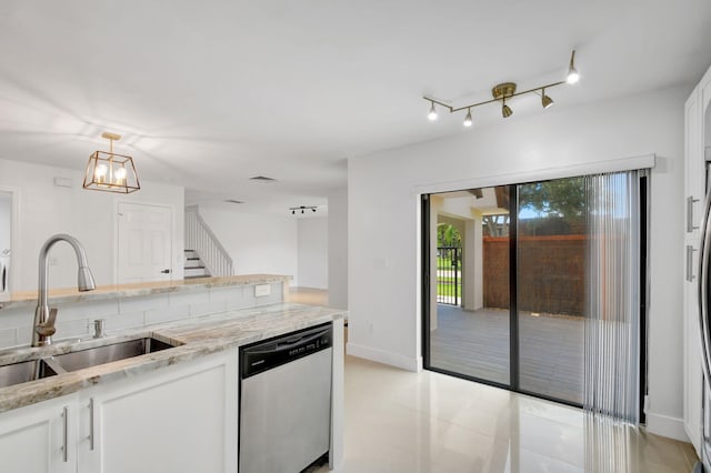 kitchen with white cabinets, pendant lighting, sink, stainless steel dishwasher, and an inviting chandelier