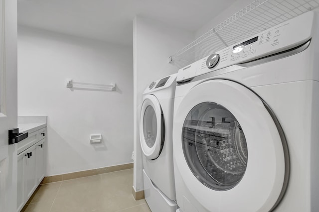 washroom featuring light tile patterned floors, washer and dryer, and cabinets