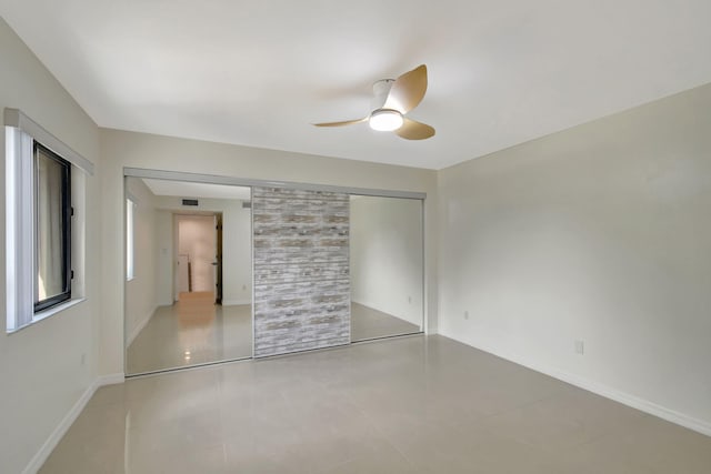 unfurnished bedroom with ceiling fan and a closet