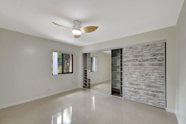 unfurnished bedroom with light tile patterned flooring, ceiling fan, and a closet