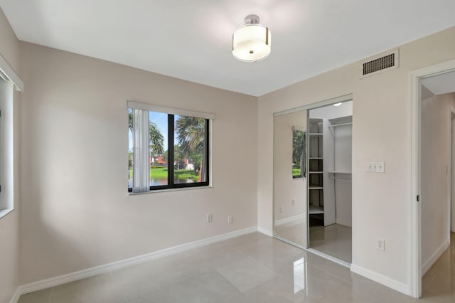 unfurnished bedroom featuring light tile patterned floors and a closet