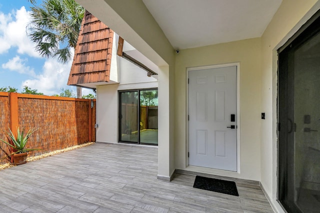 view of exterior entry with a patio area