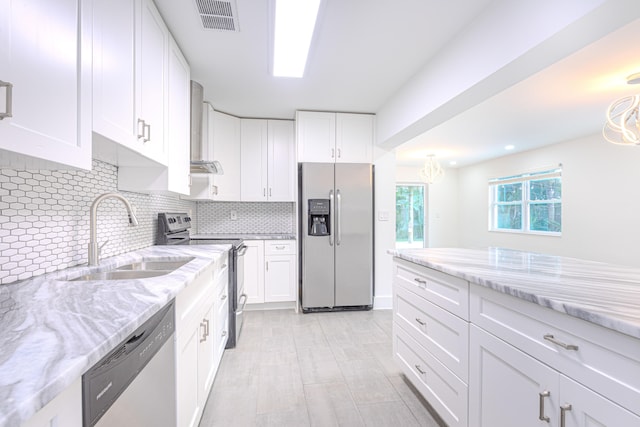 kitchen featuring white cabinets, sink, tasteful backsplash, stainless steel appliances, and light stone countertops