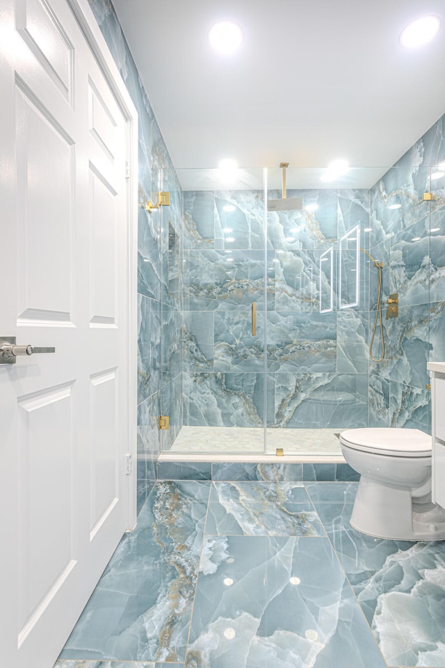 bathroom with tile walls, toilet, and an enclosed shower