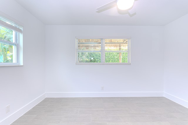 spare room featuring ceiling fan and a healthy amount of sunlight