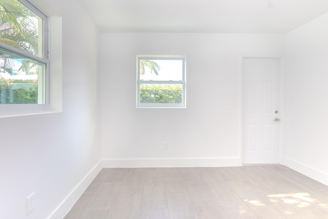 empty room with plenty of natural light and light hardwood / wood-style floors