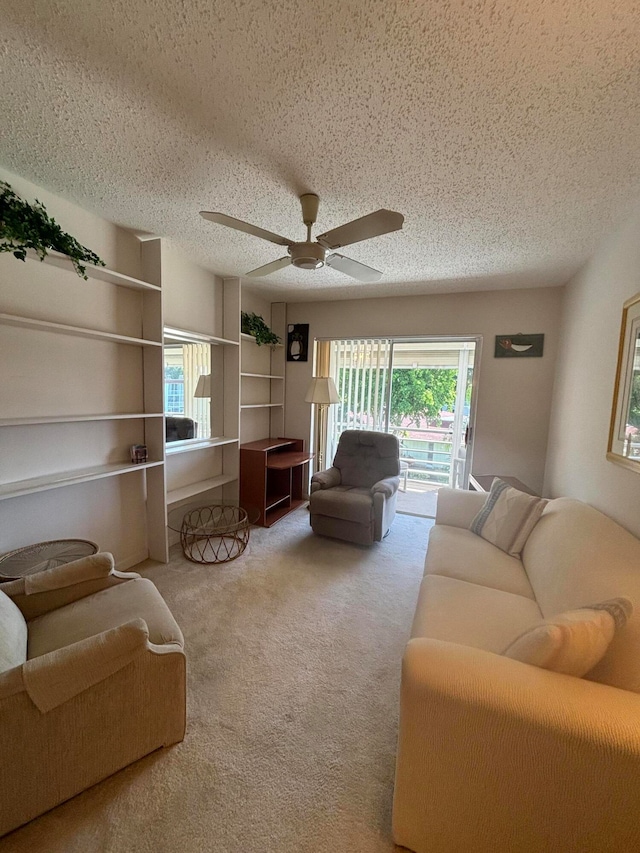 carpeted living room featuring ceiling fan and a textured ceiling