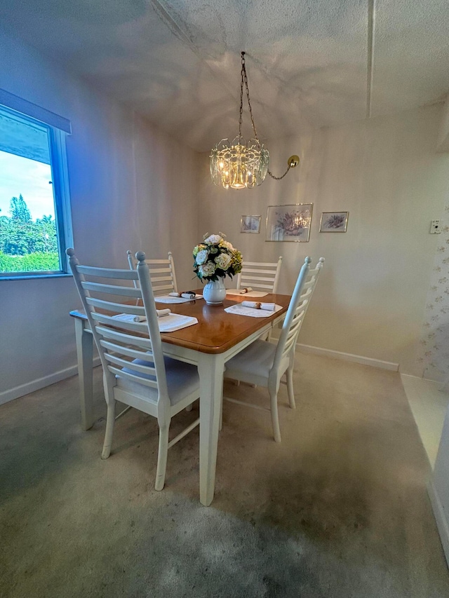 dining area with carpet flooring, a notable chandelier, and a textured ceiling