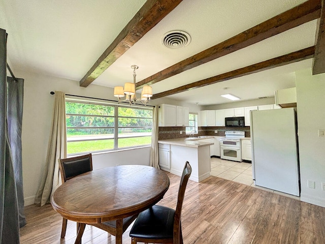 dining area featuring sink, beam ceiling, light hardwood / wood-style floors, and a chandelier