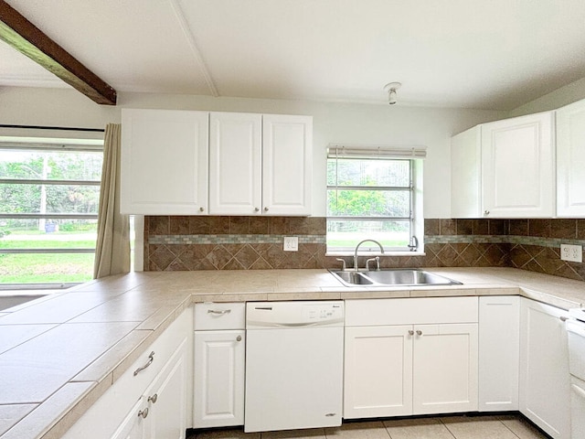 kitchen with decorative backsplash, white cabinetry, sink, and white dishwasher