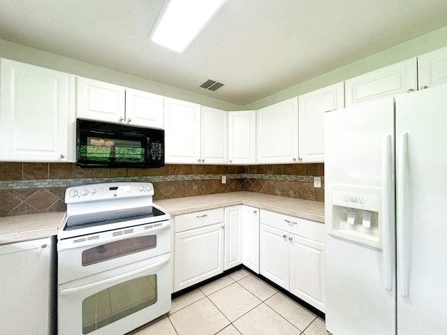 kitchen with white appliances, white cabinetry, light tile patterned floors, and tasteful backsplash