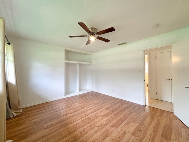 unfurnished bedroom with ceiling fan, light wood-type flooring, and a closet