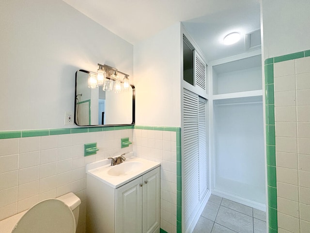 bathroom featuring tile walls, tile patterned floors, vanity, and toilet