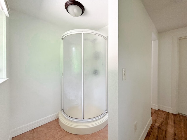 bathroom featuring hardwood / wood-style flooring and a shower with shower door