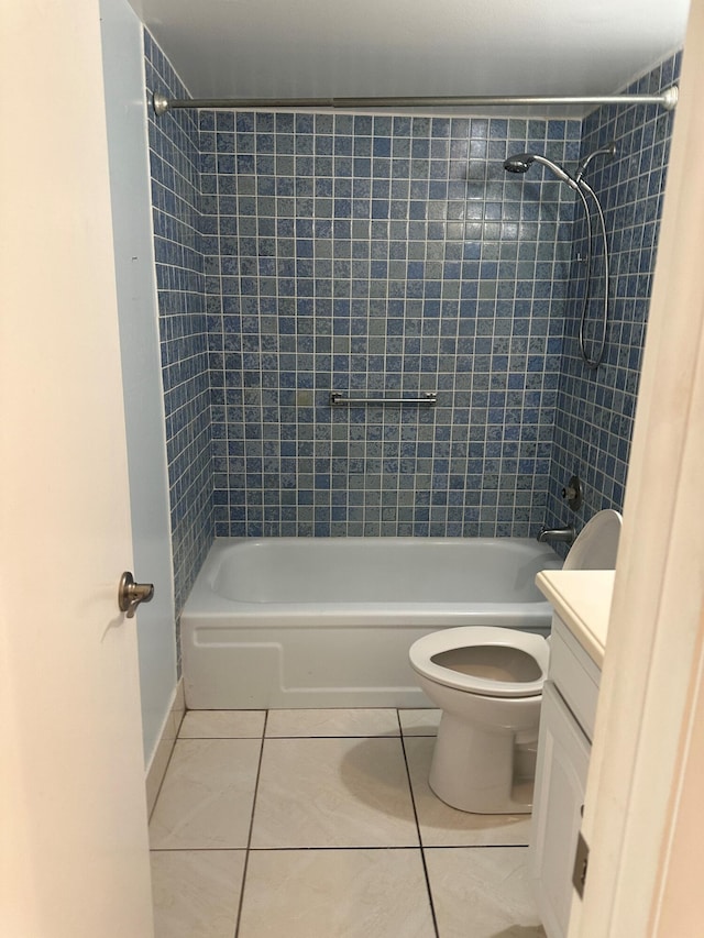 full bathroom featuring tiled shower / bath, vanity, toilet, and tile patterned flooring