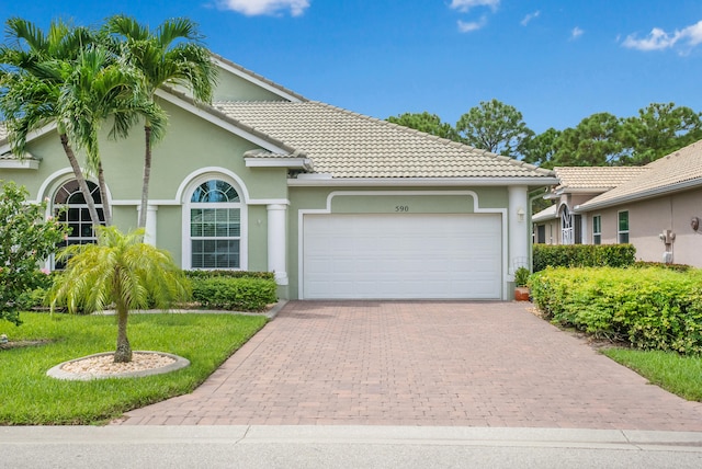 view of front of home featuring a front lawn and a garage