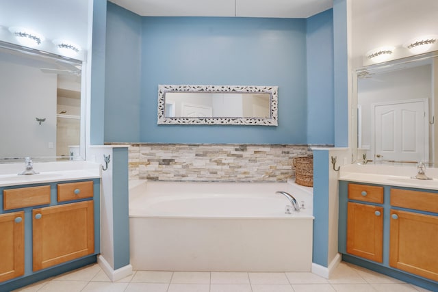 bathroom with a bath, vanity, and tile patterned floors