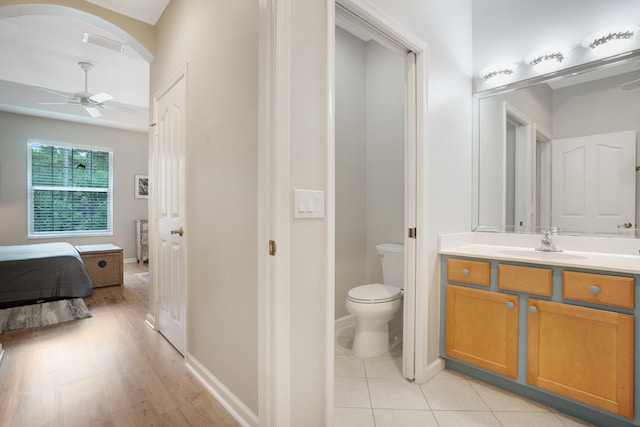 bathroom with wood-type flooring, vanity, toilet, and ceiling fan