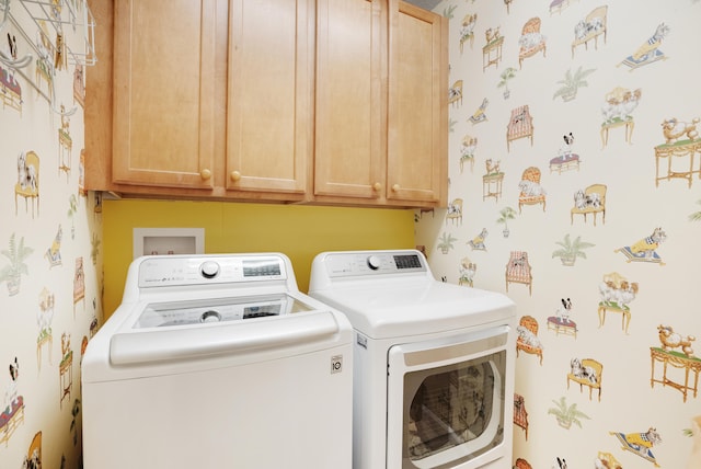 laundry room with washer and clothes dryer and cabinets