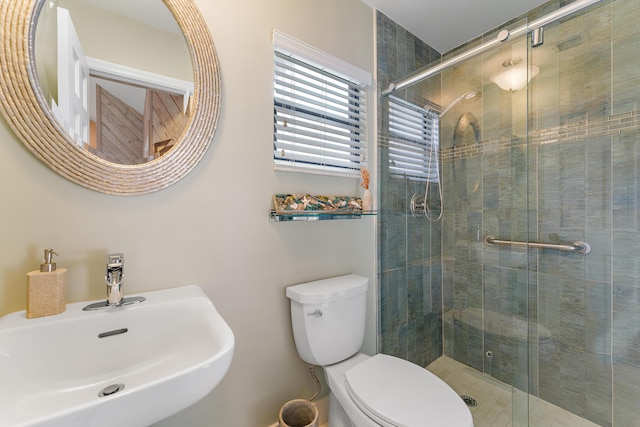 bathroom featuring toilet, an enclosed shower, and sink