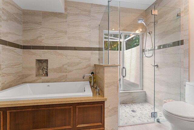 full bathroom featuring shower with separate bathtub, vanity, and toilet